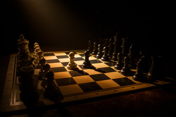 Chess board game concept of business ideas and competition. Chess figures on a dark background with smoke and fog.