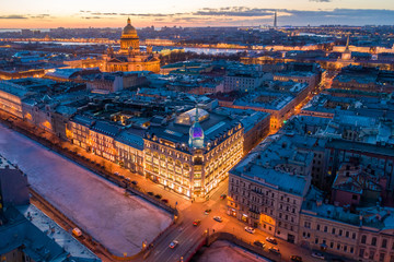 Naklejka premium ST. PETERSBURG, RUSSIA - MARCH, 2019: Department store shop class luxury, near the Red Bridge. In the background the city and St. Isaac's Cathedral, in the evening at sunset