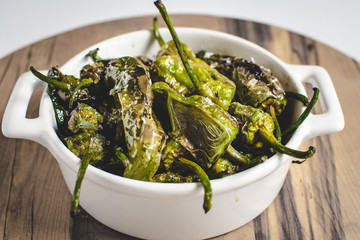 Roasted Padron Green Peppers in White Bowl. Pimientos de Padron.