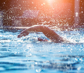 Young athletic man swimming in the swimming pool
