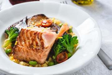 Roasted Salmon Fillet with Vegetables on Rustic White Plate. Healthy Food Concept.