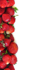 A lot of strawberry berries on a white background. A group of sweet fruits. Vitamin fruits for smoothies, cocktails and preserves. Natural products for healthy nutrition for vegetarians.