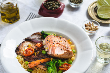 Roasted Salmon Fillet with Vegetables on Rustic White Plate. Healthy Food Concept.