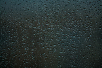 Background or texture. It is a lot of small a rain drops on window glass. Rainy day of spring.