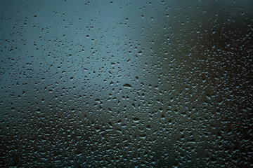 Background or texture. It is a lot of small a rain drops on window glass. Rainy day of spring.