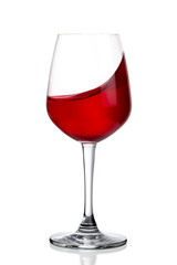 Red wine splashing out of wineglass isolated on white background.