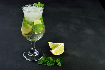 Mojito cocktail drink with lime Ice and mint on dark background with Copy space