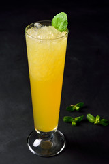 Ice cold citrus cocktail in a hight glass. Dark background with copy space for a menu.