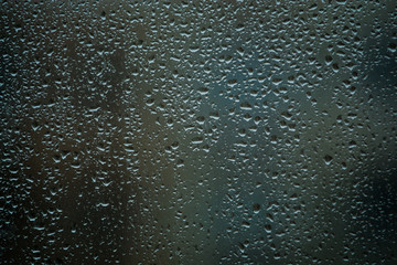 Background or texture. It is a lot of small a rain drops on window glass. Rainy day of spring.
