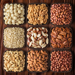 peeled assorted nuts on wooden table background. mix raw food as snack.