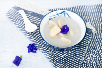 Banana in coconut milk on wooden table. Thai Dessert