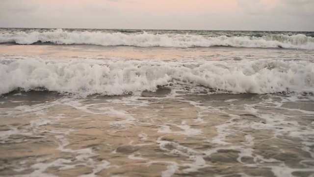 Ocean waves crashing in slow motion on a tropical beach at sunset in Recife, State of Pernambuco, Brazil