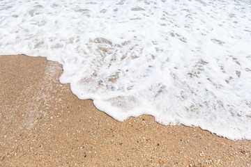 soft sea wave with foam on a sandy beach, concept of summer and vacation