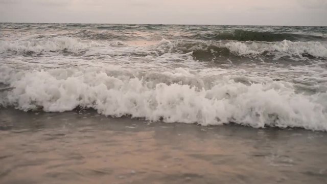Ocean waves crashing in slow motion on a tropical beach at sunset in Recife, State of Pernambuco, Brazil