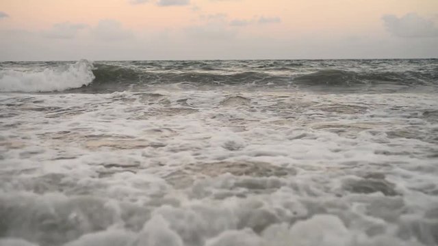 Ocean waves crashing in slow motion on a tropical beach at sunset in Recife, State of Pernambuco, Brazil