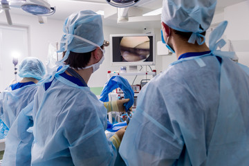 Arthroscope surgery. Orthopedic surgeons in teamwork in the operating room with modern arthroscopic...