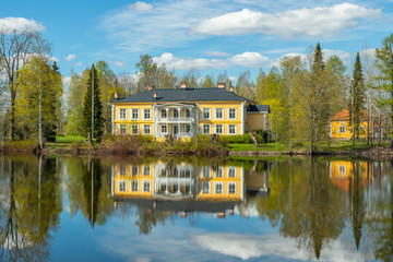 Fototapeta na wymiar Kouvola, Finland - May 16, 2019: Beautiful wooden Rabbelugn Manor - Takamaan Kartano. Wrede family house was built in 1820 on the river Kymijoki bank.
