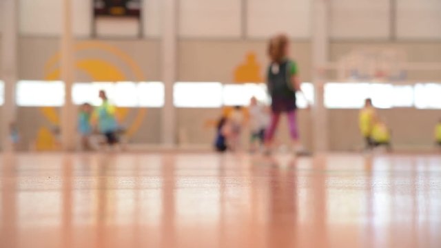 Unfocused scene of a group of children running and exercising in a sports pavilion with their school