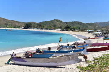 Fototapeta na wymiar Fishing boats on the white sands of Pantai Mawun beach in Lombok Island, Indonesia
