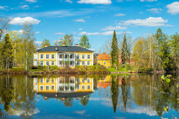 Fototapeta premium Kouvola, Finland - May 16, 2019: Beautiful wooden Rabbelugn Manor - Takamaan Kartano. Wrede family house was built in 1820 on the river Kymijoki bank.
