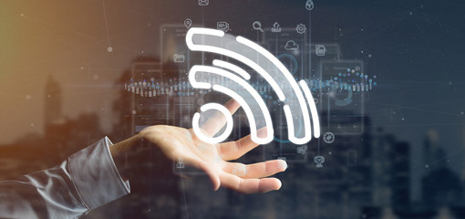 Businessman holding a wifi icon with data all around