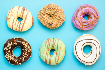 Donuts assorted with glazed on blue and pink background