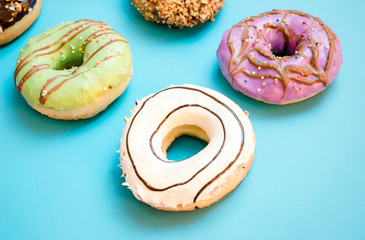 Donuts assorted with glazed on blue and pink background