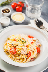 Delicious salmon linguine pasta dish with herbs and grilled salmon filet.