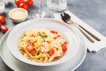 Delicious salmon linguine pasta dish with herbs and grilled salmon filet.