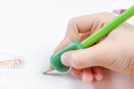 child's hand with writing tool for help by incorrect holding of pencil