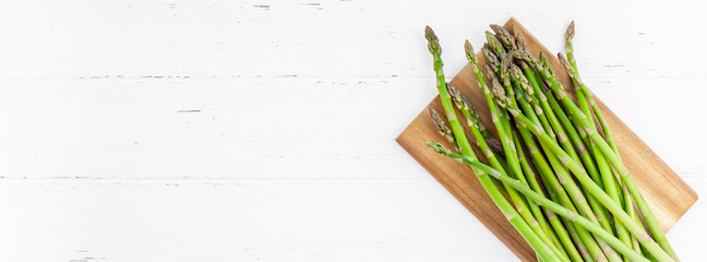 Fresh green asparagus on white wooden background