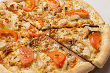 Italian pizza with slices of chicken and walnut, pizza cut, close-up