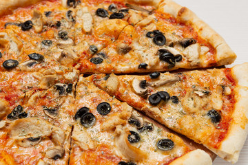 Italian pizza with chicken, mushrooms and olives, pizza cut, close-up