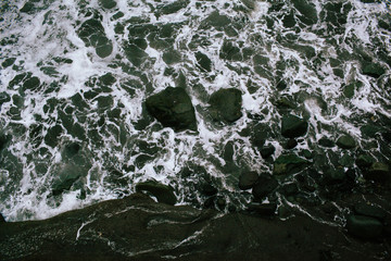 Waves of a raging dark sea crashing on rocks