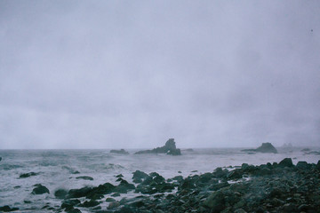 Waves of a raging dark sea crashing on rocks