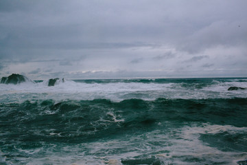 Waves of a raging dark sea crashing on rocks