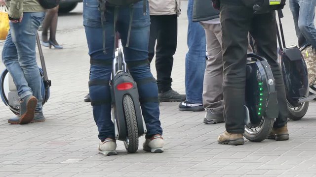 Personal electric transport, monowheel. Close-up, many legs on monowheels. Collection of electric transport lovers.