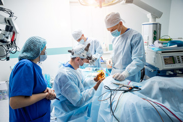 Brain surgery. Group of surgeons in operating room with surgery equipment.