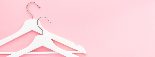 White hangers on pastel pink background
