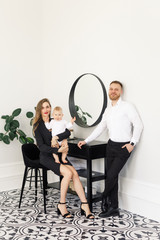 Obraz premium young beautiful family stylishly dressed standing in a bright apartment