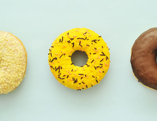 Delicious donuts on light pastel color background. National Donut Day concept.