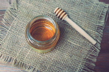 Honey with honey dipper on wooden table