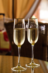 two glasses with champagne on a table in a restaurant