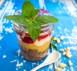 Przekładany deser w słoiku, udekorowany miętą. © Michał