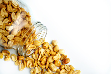 Roasted peanuts in the glass bottle on white background for advertising. Clean food good taste ideas concept. Selective focus and free space for text.