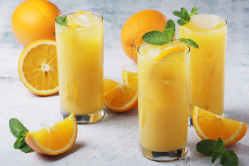 Glasses full of orange juice with ice	