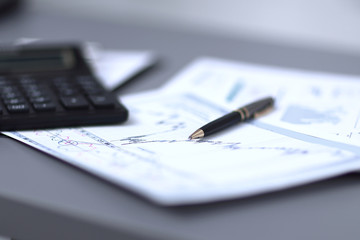 close up.pen, financial chart and calculator on the businessman's Desk