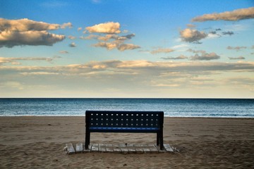 Bench on the beach of Alicante at sunset