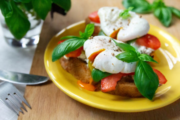 Healthy breakfast sandwiches with basil, tomato and poached egg
