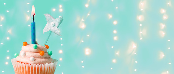 Celebratory cupcake with a decorative lit candle